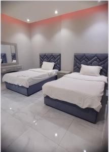 two beds sitting next to each other in a bedroom at شقق هدى مون ليت in Al Kharj