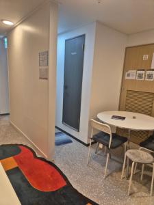 a room with a table and chairs and a door at All Stay Hostel in Seoul