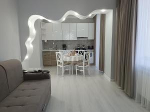 a living room and kitchen with a table and chairs at Апартаменты Энглер in Aktobe