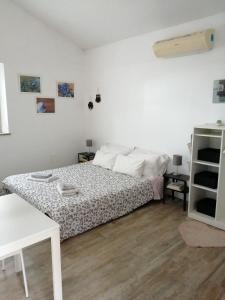 a white bedroom with a bed and a table at La casetta nel bosco in Manciano