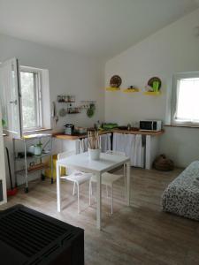 a living room with a white table and chairs at La casetta nel bosco in Manciano +2 photos