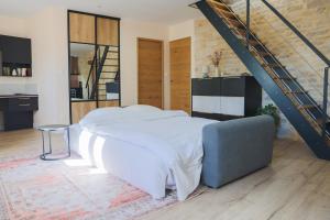 a bedroom with a white bed and a staircase at Mia Cambro in Tournus