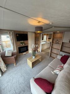 una sala de estar con un sofá y una mesa en Goldfinch Lodge at Brickyard Lakes, en Amotherby