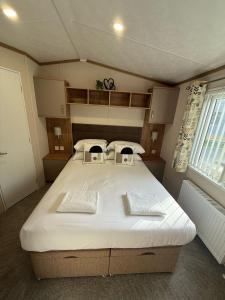 un dormitorio con una cama grande en una habitación en Goldfinch Lodge at Brickyard Lakes, en Amotherby