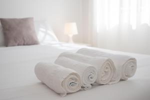 a pile of rolled towels on a bed at SIBS Sanlúcar Océano-Ideal Familias-Parking y Wifi Gratis in Sanlúcar de Barrameda