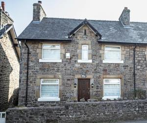 a brick house with a brown door and windows at Smithy Cottage in Heysham