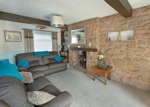 a living room with a couch and a stone wall at Smithy Cottage in Heysham +6 photos