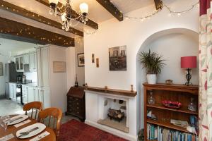 a living room with a fireplace and a table at Smithy Cottage in Heysham