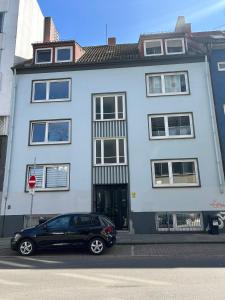 a black car parked in front of a white building at Modernes 2 Zimmer Apartment mit Balkon, zentrale Lage in Bremen