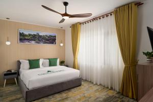 a bedroom with a bed and a ceiling fan at Smile Boutique Hotel By EHM in Phnom Penh