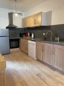 a kitchen with wooden cabinets and white appliances at L'Intemporel in Clermont-Ferrand