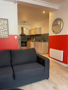 a living room with a couch and a kitchen at L'Intemporel in Clermont-Ferrand