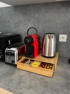 a coffee maker on a wooden tray next to a toaster at L'Intemporel in Clermont-Ferrand