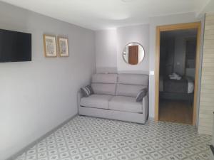 a living room with a couch and a bedroom at APARTAMENTOS CASA FREDI - Apartamentos les cuartes 1 y 2 in Cardes
