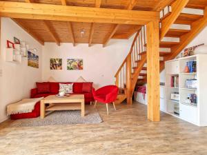 a living room with a red couch and a table at Sturmfrei in Greetsiel