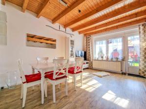 a dining room with a white table and chairs at Sturmfrei in Greetsiel