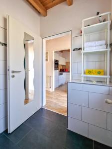 a kitchen with white cabinets and an open door at Sturmfrei in Greetsiel