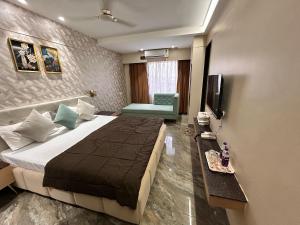 una habitación de hotel con una cama y un televisor en Hotel Mangal Shree, en Ujjain