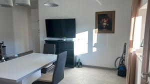a dining room with a white table and a tv at Danner Worker Rooms Schörfling - Ruhige Appartements mit Küche für Arbeiter & Firmen in Schörfling