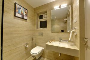 a bathroom with a sink and a toilet and a mirror at Iris Beacon Hotel in Rajkot +23 photos