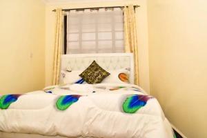 a bedroom with a white bed with a window at KenPam BNB in Isiolo