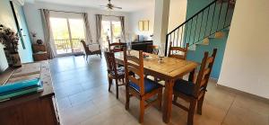 a dining room with a wooden table and chairs at Casa Londi in Almuñécar +15 photos