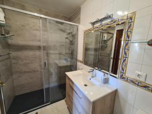łazienka z prysznicem, umywalką i lustrem w obiekcie Acogedor dúplex en urbanización con piscina en Ajo w mieście Ajo