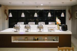 a kitchen with a sink and a counter with lights at Surigao Royal Regency Suites in Surigao