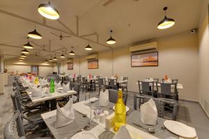a dining room with tables and chairs and lights at Iris Beacon Hotel in Rajkot