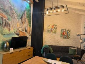 a living room with a couch and two paintings on the wall at Casa del Agua in Cazorla