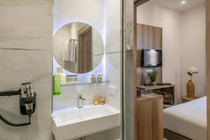 a bathroom with a sink and a mirror at GOLDEN TULIP CANNES HOTEL de PARIS in Cannes
