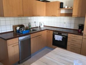 a kitchen with wooden cabinets and a sink and a dishwasher at zum Handwerker Glück Boschhorn in Ichenhausen