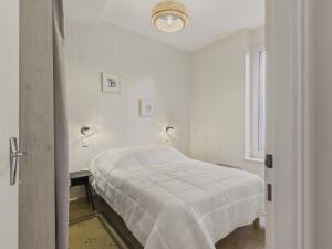 una camera da letto bianca con un letto e una finestra di Escapade à 2 au Pouliguen - 160m de la plage a Le Pouliguen