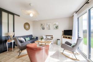 a living room with a couch and chairs and a tv at Maison pour 6 avec jardin à 500 m de la plage in Lilia