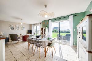 a kitchen and dining room with a table and chairs at Maison pour 6 avec jardin à 500 m de la plage in Lilia