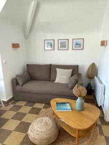 a living room with a couch and a table at L'Escapade in Fort-Mahon-Plage +14 photos