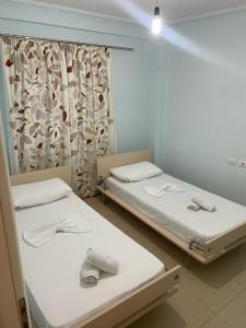 Dos camas en una habitación de hospital con ventana. en Andria Apartment, en Sarandë