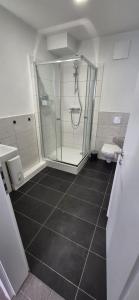 a bathroom with a glass shower and a toilet at Living Home in Braunschweig
