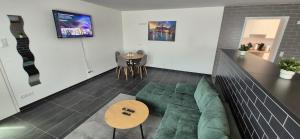 a living room with a green couch and a table at Living Home in Braunschweig