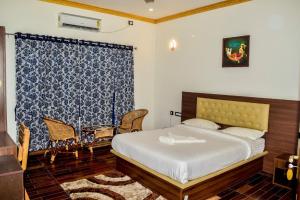 1 dormitorio con cama y cortina azul y blanca en Kudajadri Heritage Pool Homestay Kothamangalam, en Kotamangalam