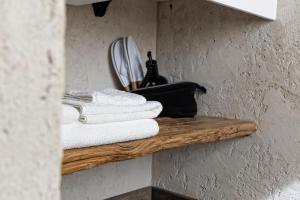 a wooden shelf with towels on a wall at Domus Mea Suites in Costermano +42 photos
