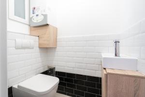 ブダペストにあるGetaway Oasis Apartmentの白いトイレと洗面台のあるバスルーム +13枚の写真
