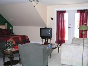 a living room with a bed and a tv and a couch at Two Eagles Lodge in Union Bay