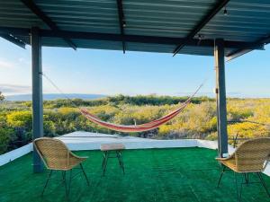 a hammock on a patio with chairs and a view at Villa Bella with private pool and high speed internet in Puerto Villamil