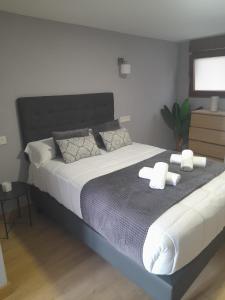 a bedroom with a large bed with two towels on it at APARTAMENTOS CASA FREDI - Apartamentos les cuartes 1 y 2 in Cardes