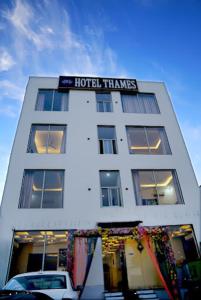 a white building with a hotel things sign on it at Hotel Thames in Zirakpur