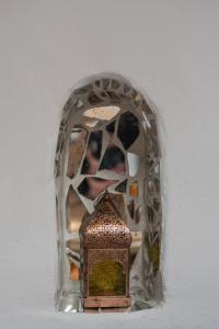 a small moroccan clock in front of a mirror at Casa Walhalla & Cortijo El Páramo in Pampaneira
