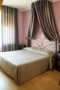 una camera con un grande letto a baldacchino di Hotel Continental a Torino
