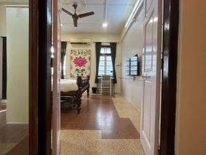 a hallway with a bed and a ceiling fan at Sasha in Mumbai