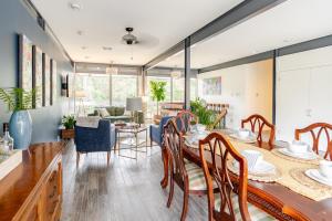 a dining room and living room with a table and chairs at Glass House retreat on scenic Bogue Falaya river in Covington